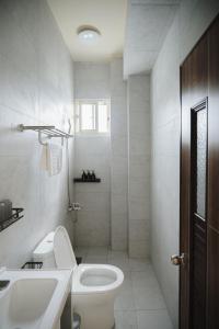a white bathroom with a toilet and a sink at 綠島 棲間民宿 Green Island Roost B&B in Green Island