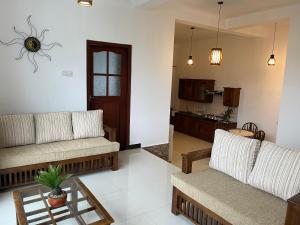a living room with two couches and a table at Cottage Fifty One in Kandy +8 photos