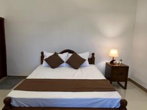 a bedroom with a bed and a night stand with a lamp at Cottage Fifty One in Kandy