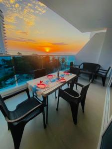 a dining room with a table and chairs and a sunset at Reserva del Mar 539 in Santa Marta