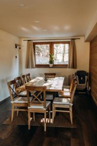 a dining room with a table and chairs and a window at Ta Chalupa in Prostřední Bečva