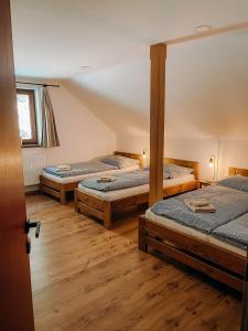 three beds in a room with wooden floors at Ta Chalupa in Prostřední Bečva
