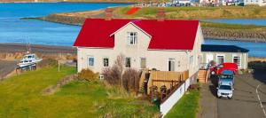 a white house with a red roof on a hill at Guesthouse Kiljan in Blönduós