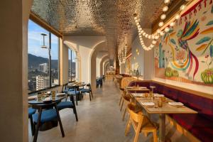 a dining room with tables and chairs in a restaurant at Moxy Kathmandu in Kathmandu