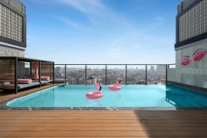 a swimming pool with pink flamingos in a building at Moxy Kathmandu in Kathmandu