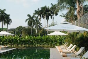 a group of chairs and umbrellas next to a pool at Sadec Garden Boutique Hotel in Ấp Tân Thành (2)