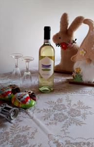 a bottle of wine sitting next to a stuffed animal and glasses at La Casa di Marla in Sirmione