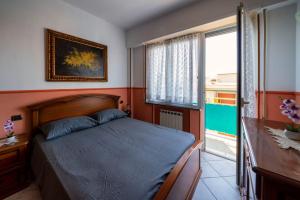 a bedroom with a bed and a window at Affittacamere Le Palme in Ospedaletti