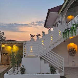 a staircase leading up to a house with potted plants at BeaMare Suites in Bantay