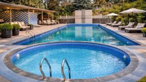 a large swimming pool with blue water at Motus Mountain view Hotels in Jambhulpāda