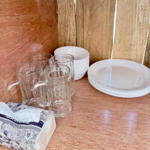 a group of glasses and plates on a wooden table at BeaMare Suites in Bantay +24 photos