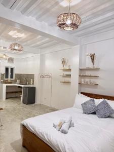 a bedroom with a white bed and two chandeliers at BeaMare Suites in Bantay