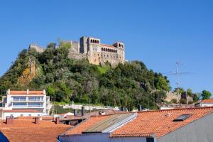 a castle on top of a hill with roofs at Castle Boutique Studio in Leiria +8 photos