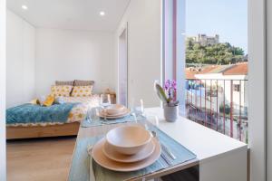 a room with a bed and a table with plates on it at Castle Boutique Studio in Leiria