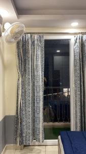 a room with a window with curtains and a fan at The Horizon House in Zirakpur