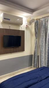 a bedroom with a bed and a tv and a fan at The Horizon House in Zirakpur