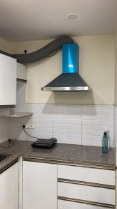 a kitchen with a blue hood over a counter at The Horizon House in Zirakpur