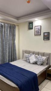 a bedroom with a bed with blue sheets and pillows at The Horizon House in Zirakpur