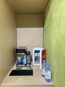 a kitchen with a coffee maker and water bottles on a counter at Лофт отель 11eleven in Shymkent