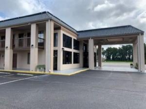 a large building with a parking lot with at Days Inn by Wyndham Clinton in Clinton
