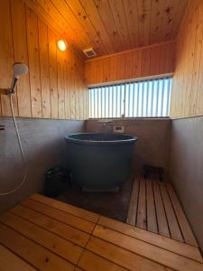 a bath tub in a wooden bathroom with a window at ゐらくさ in Yaizu +10 photos
