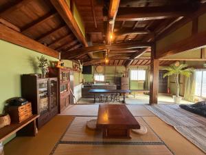 a large living room with a table and a kitchen at ゐらくさ in Yaizu