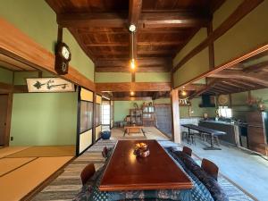 a dining room with a table and a kitchen at ゐらくさ in Yaizu