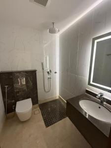 a bathroom with a shower and a toilet and a sink at نون Noon in Medina +9 photos