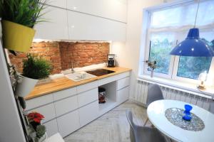a kitchen with white cabinets and a table and a window at Cazare Ceronav CityCenter Galati in Galaţi