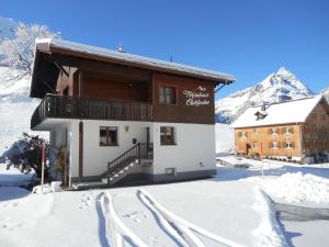 a building in the snow with tracks in the snow at Ferienhaus Oberboden in Schröcken