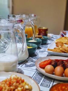a table with plates of food and jars of milk at Wild Haven Lodge in Victoria Falls
