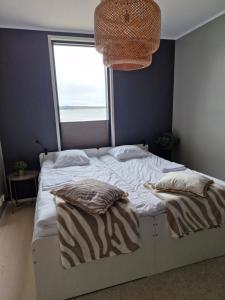 a bedroom with a large bed with a window at Huvilarannalla in Sotkamo