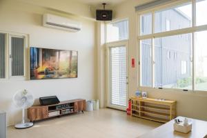 a living room with a fan and windows at 綠島 棲間民宿 Green Island Roost B&B in Green Island