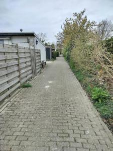 a brick road next to a fence and a building at Zonnehoek in Bruinisse