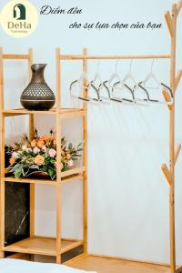 a wooden shelf with a vase and flowers on it at DeHa Homestay in Kon Rung (1)