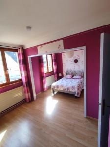 a bedroom with a bed in a room with purple walls at Chez Famille RENTZ in Riquewihr