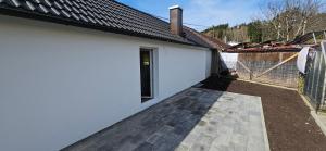 a white garage with a gate and a fence at Allgaeuerferienwohnung Schneider in Woringen