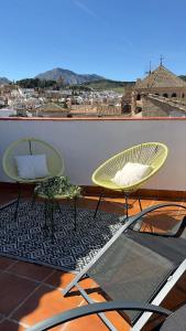 two chairs on a balcony with a view of a city at CASA VERA, Casa completa para familias o grupos en el centro de Antequera in Antequera