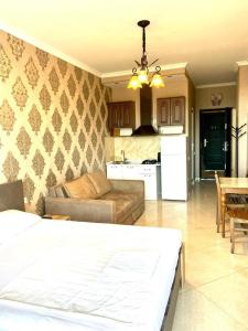 a living room with a couch and a kitchen at Apartamenti Panorama in Kobuleti
