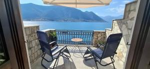 a balcony with two chairs and a table and water at Kadena Apartments in Kotor