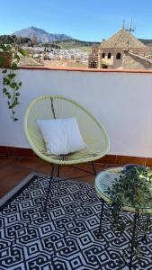a green chair with a pillow and a table at CASA VERA, Casa completa para familias o grupos en el centro de Antequera in Antequera +38 photos