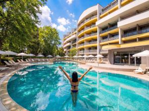 a woman is standing in the swimming pool at a hotel at Hotel Perunika in Golden Sands