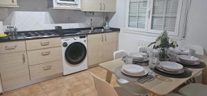 a kitchen with a table and a washing machine at BIZIA Vida Apartamento 5 in Sopuerta