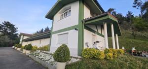 a house with a green and white building at BIZIA Vida Apartamento 5 in Sopuerta