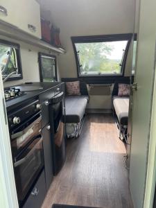 an interior of an rv with two windows and a kitchen at Camping pod in Greatham