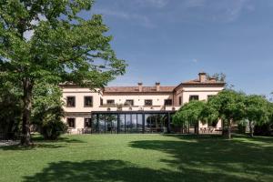 a large building with a large yard with trees at Relais Villa Margherita in Longiano