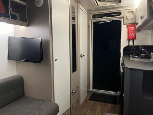 a small room with a tv and a sink in an rv at Camping pod in Greatham