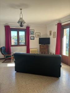 a living room with a couch and a tv at Maison tout confort équipée Camargue in Saint-Gilles