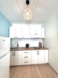a kitchen with white cabinets and a sink at The blue lagoon in Ohrid