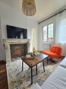 a living room with a coffee table and a fireplace at La Tour d'Harfleur 1 in Caudebec-en-Caux